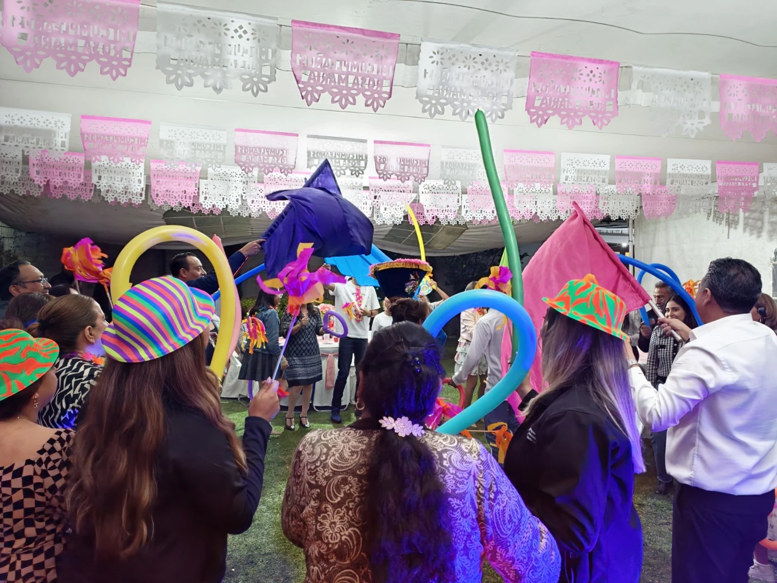 Invitados con sombreros, banderas y globos de colores