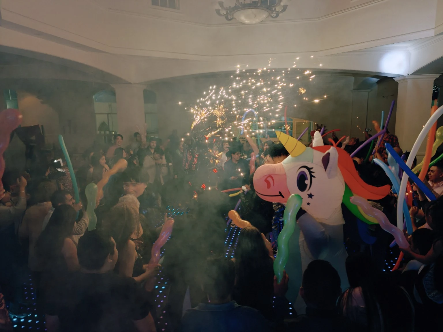 Invitados y personaje de unicornio en la pista durante la batucada
